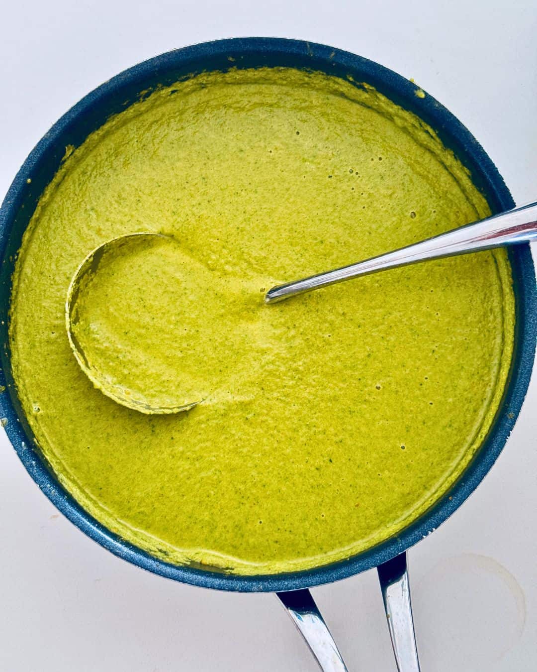Creamy broccoli soup in a pot with a ladle, ready to serve
