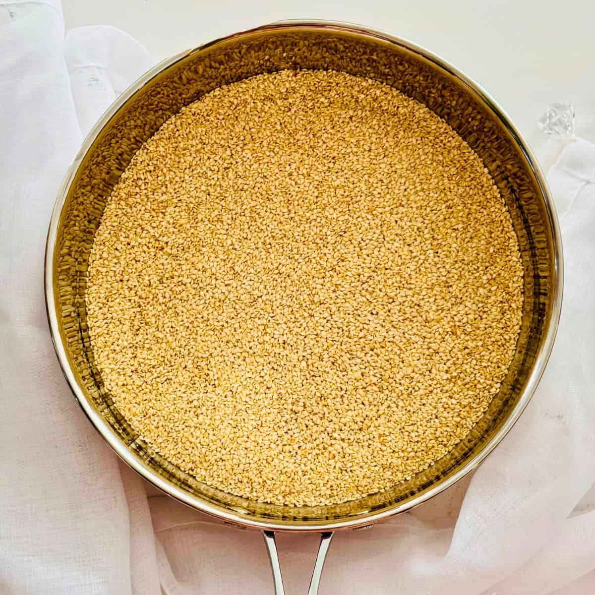toasted seeds in a silver pan homemade tahini recipe