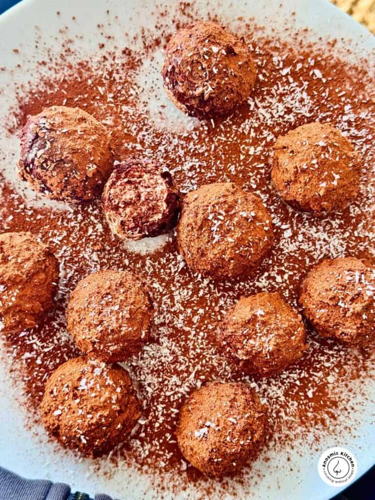 cottage cheese chocolate balls rolled coconut one is halved to show the inside.