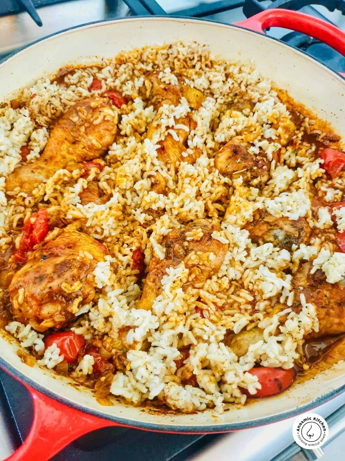 rice over chicken in a skillet