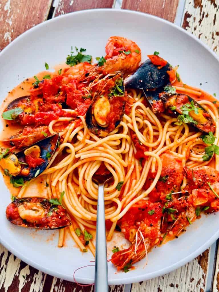 Italian-style seafood marinara with prawns, clams, and mussels in tomato sauce over spaghetti