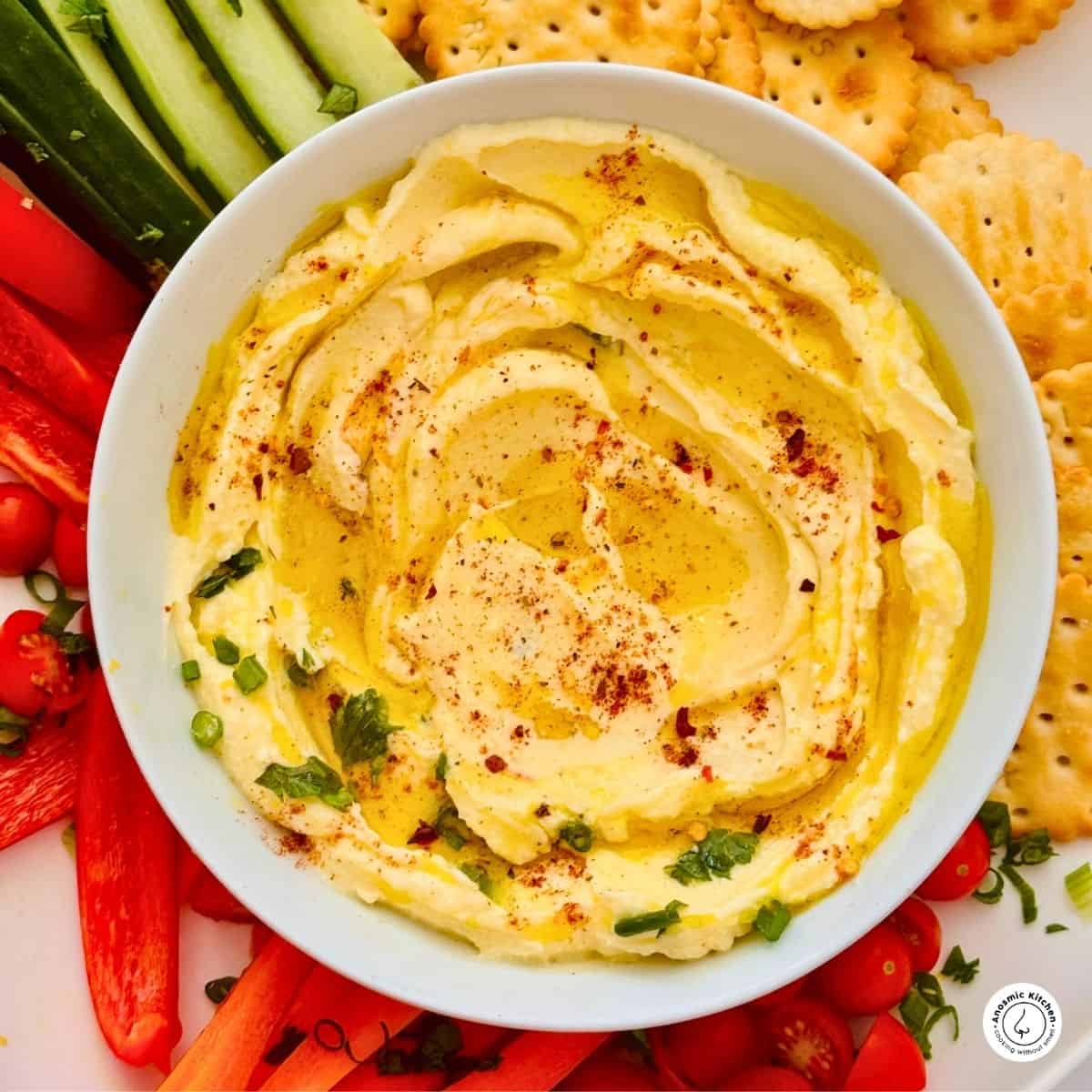 mascarpone cheese dip in a bowl on a platter with sliced fresh veggies around it
