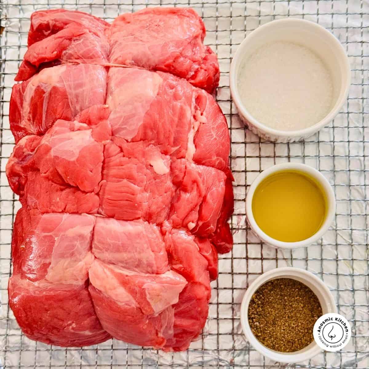 rolled beef with salt pepper and olive oil on a cooling rack