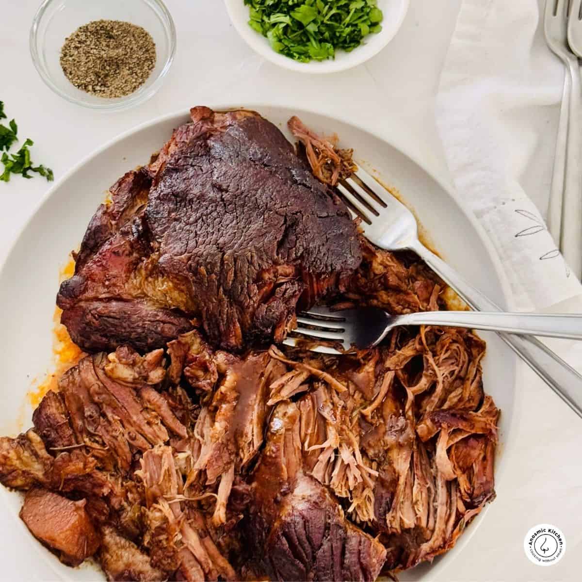 pot roast boneless beef chuck on a white plate and two forks