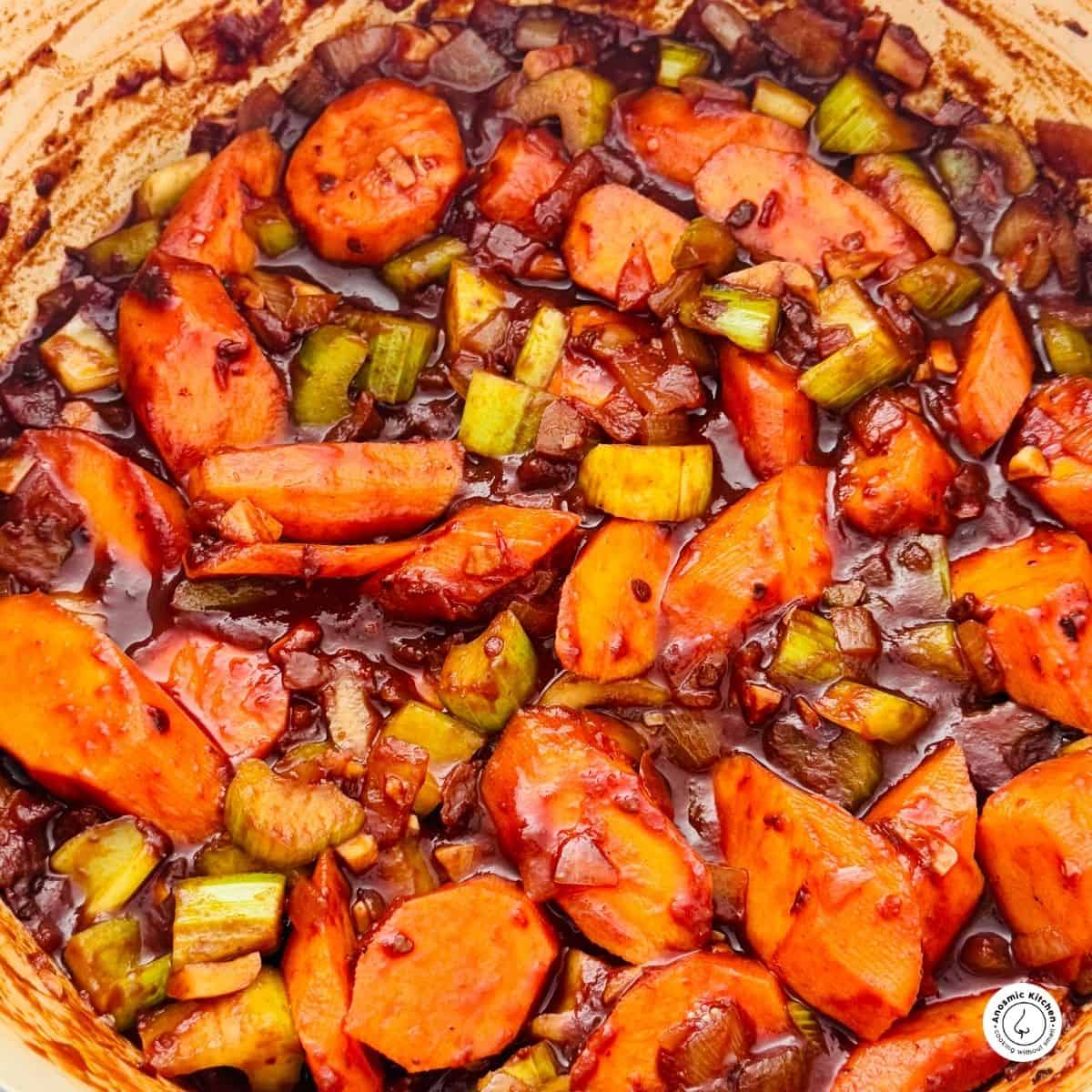 carrots, celery and onion chopped and cooking in a pot for a soffritto