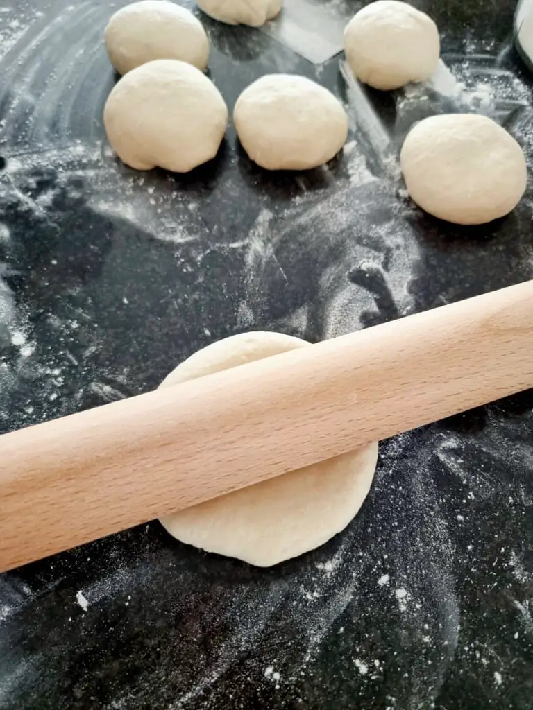 pita bread rolled into balls with a rolling pin