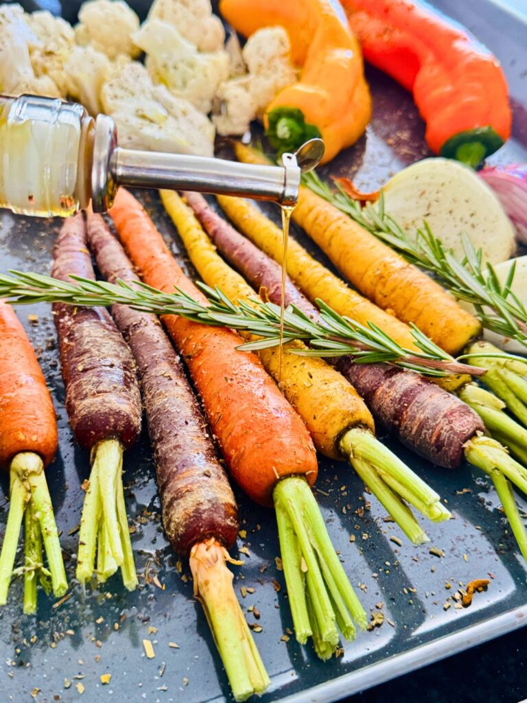fresh vegetables on a sheet pan prepared for roasting.