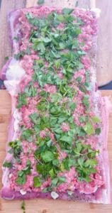 pork belly slab with minced meat on and fresh herbs