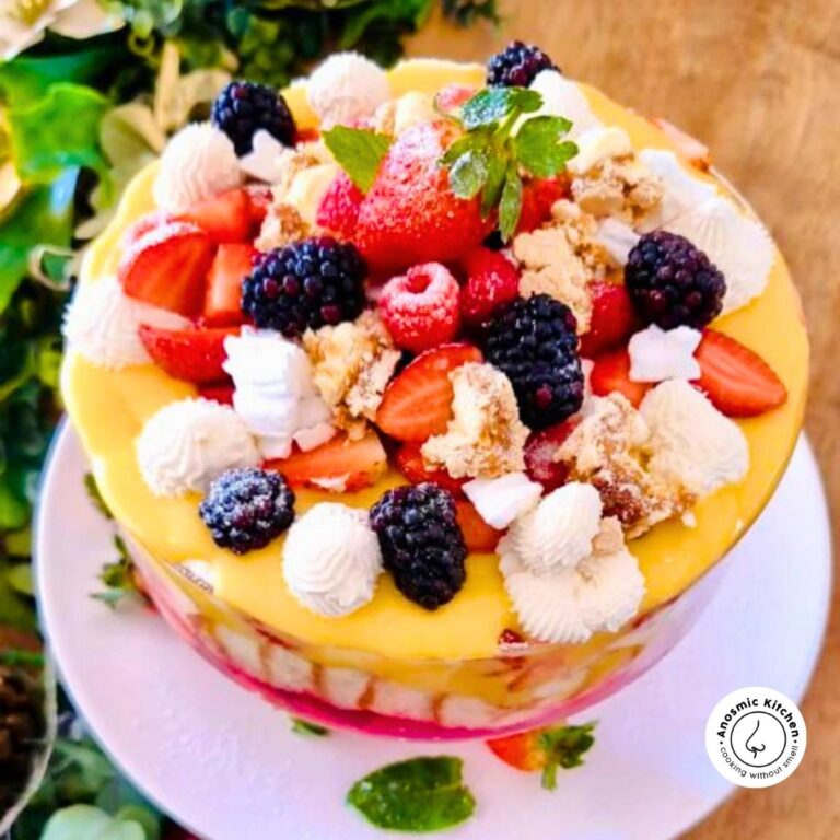 jelly, custard, and fruit trifle in a large glass dessert serving bowl