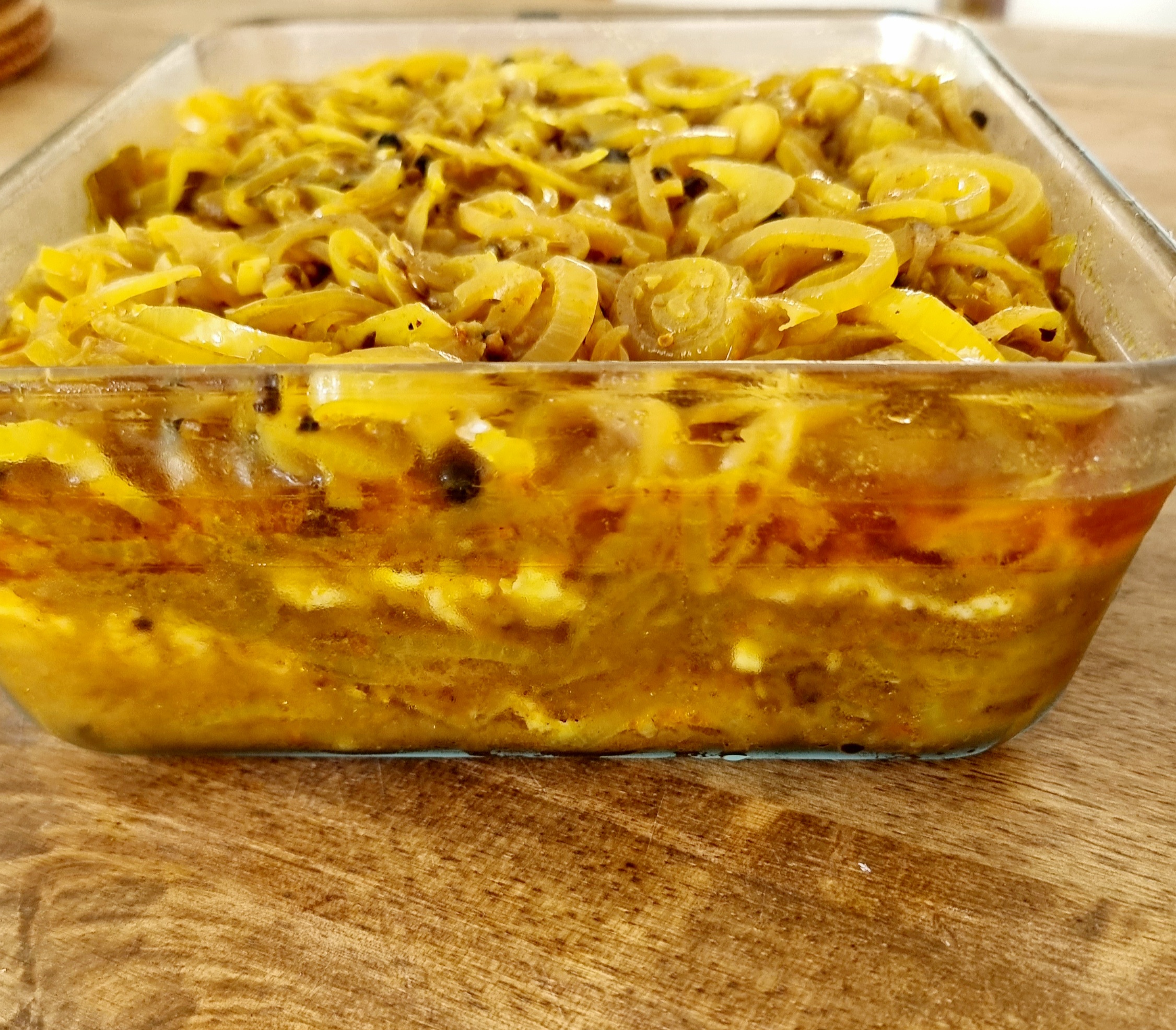 Prepared pickled fish stored in a glass Pyrex dish, ready for refrigeration