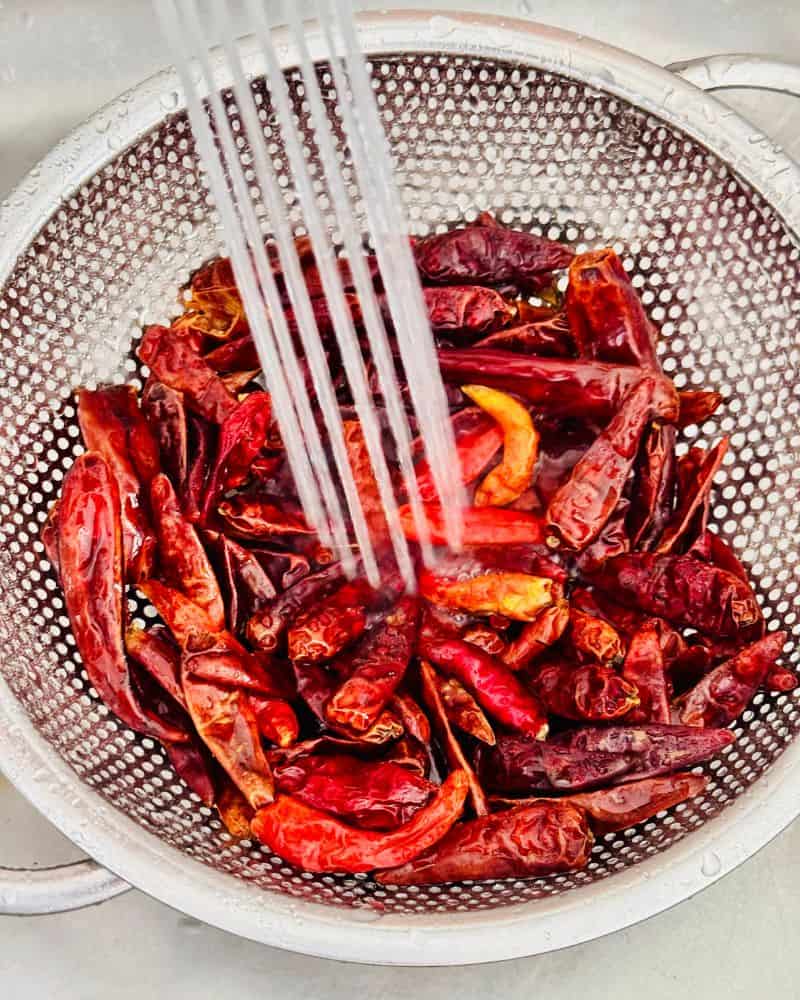 dried chllis rinsed under a running tap in a colander