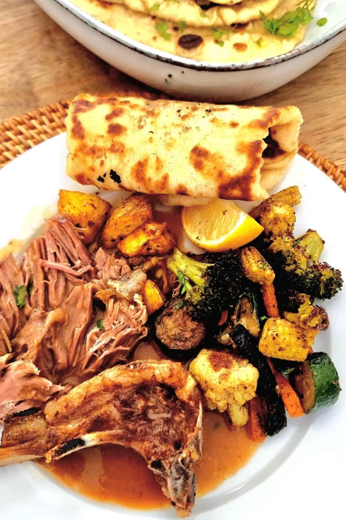 slow cooked lamb served with naan and vegetables