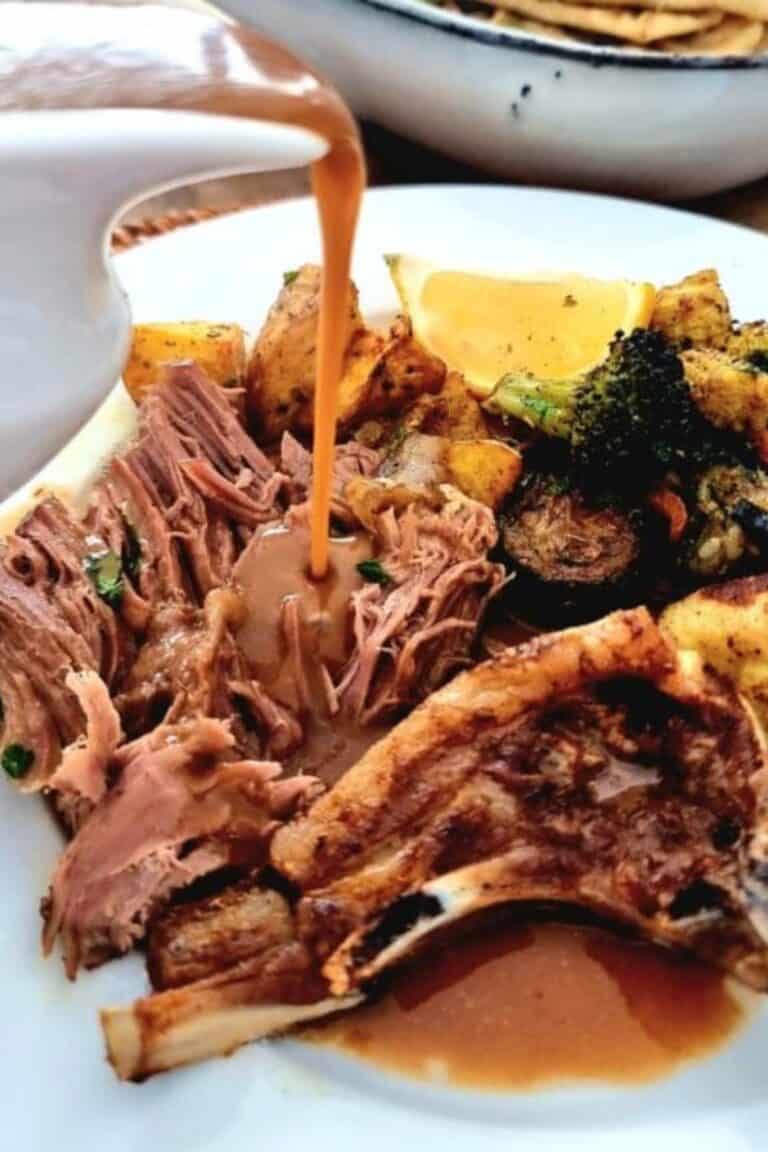 lamb roast bone-in shredded with gravy pouring over
