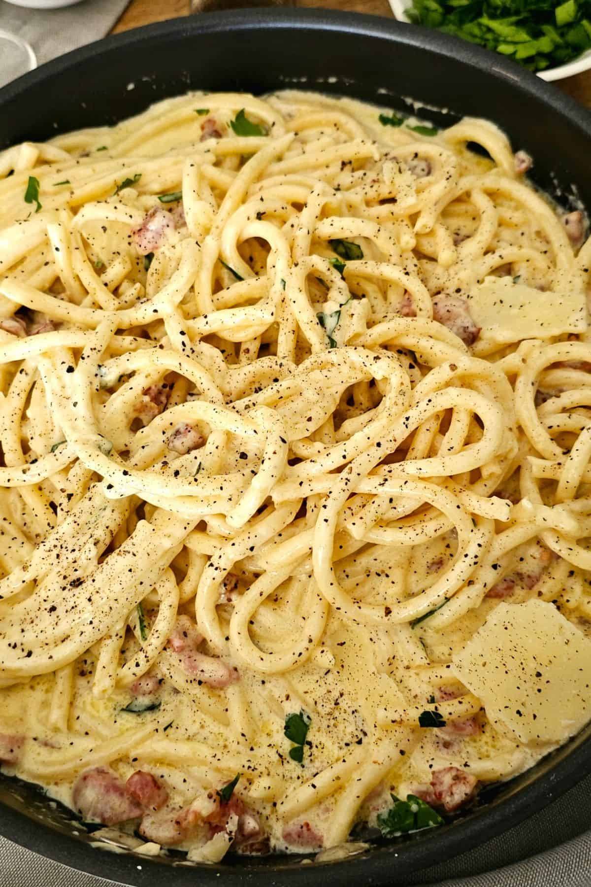 creamy spaghetti with cheese and bacon in a pan