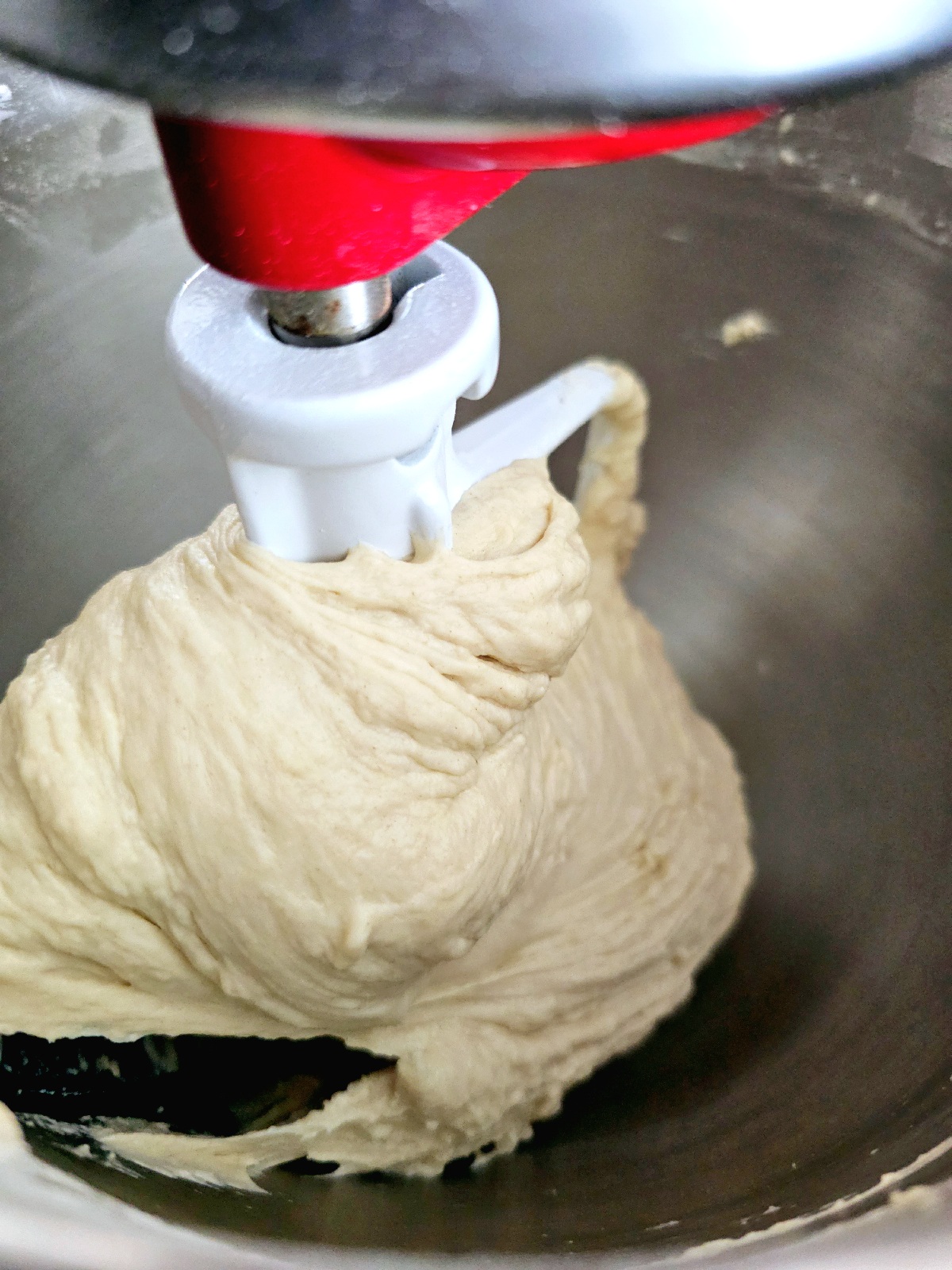 soft and fluffy naan bread dough on a hook in stand mixer