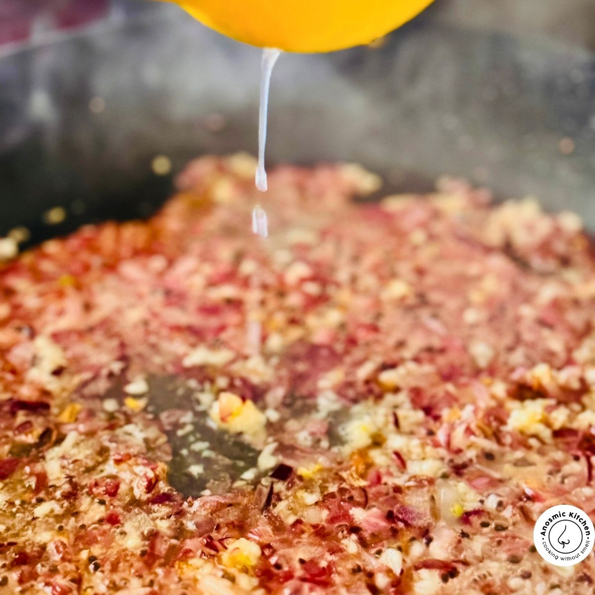 adding lemon into sizzling onions