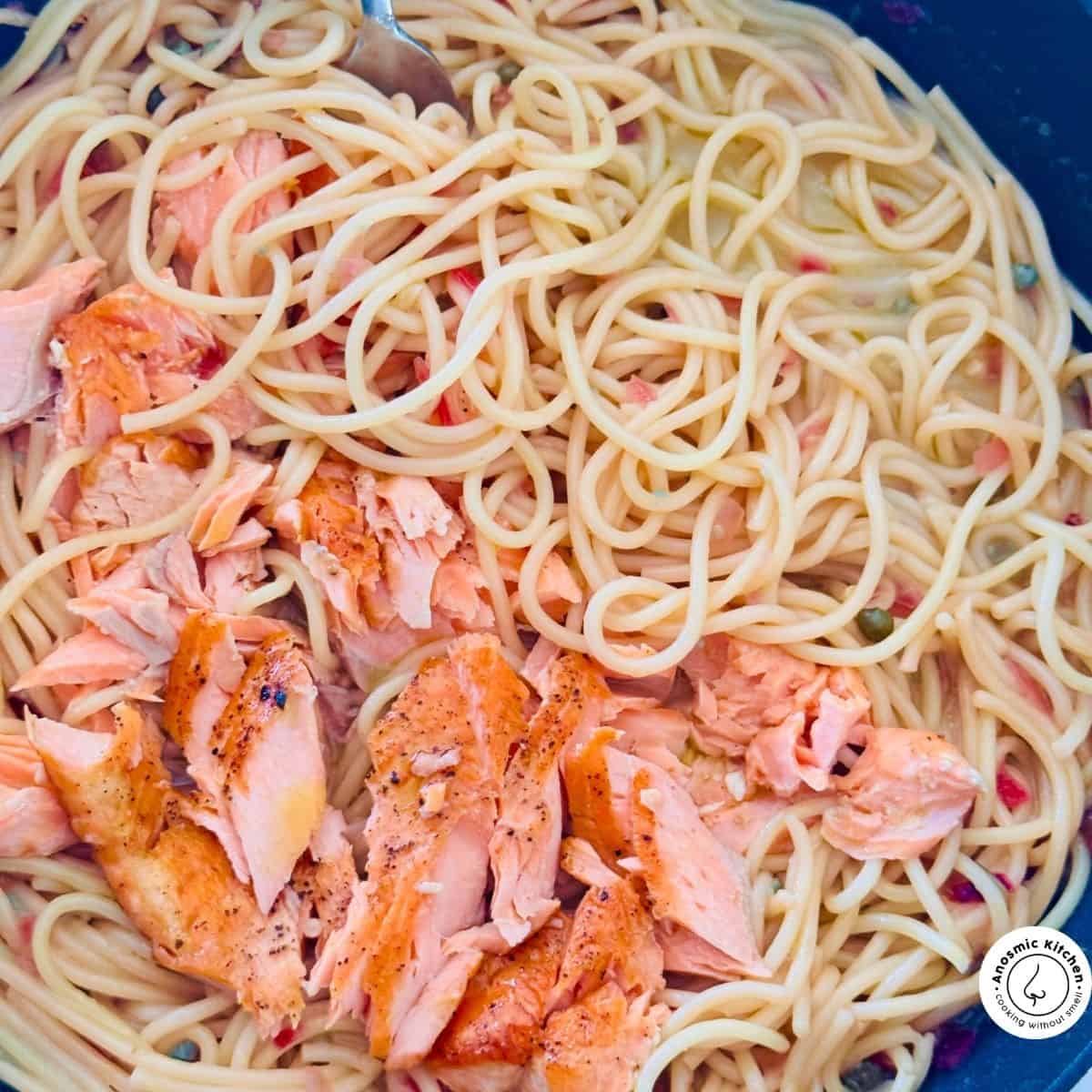 cooking salmon and pasta in pan