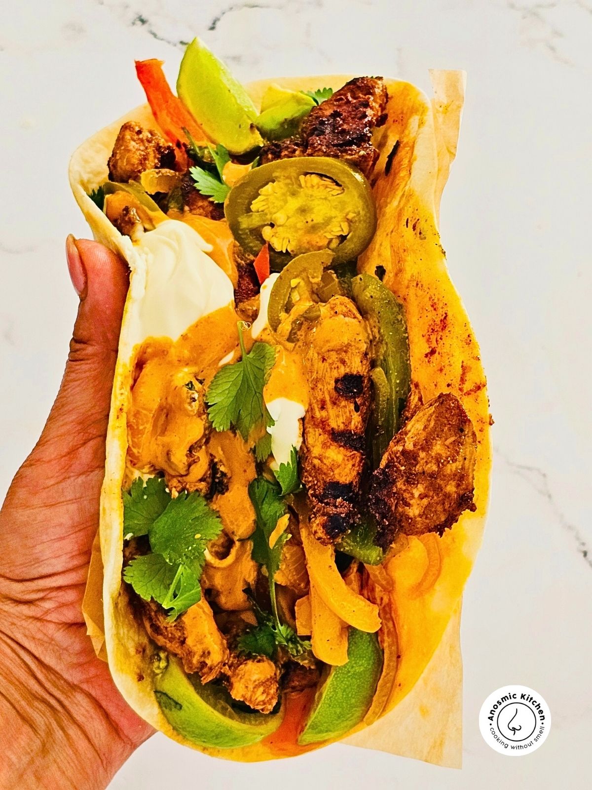 chicken fajita wrap in hand with filling