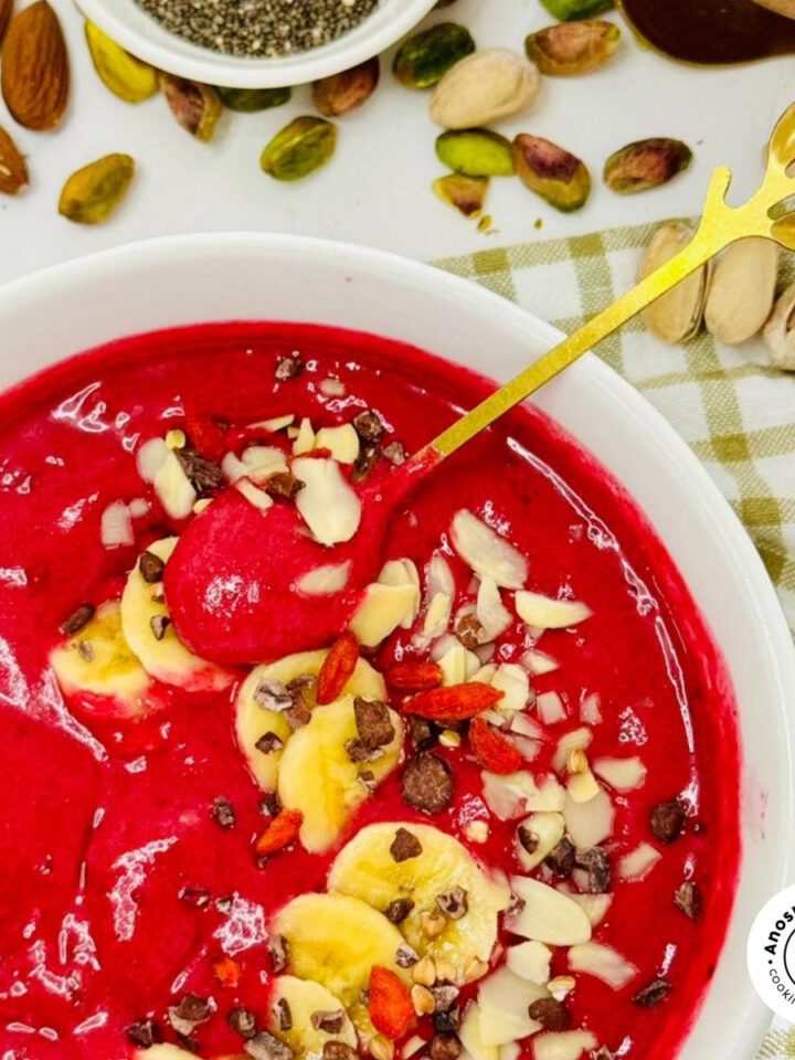 beetroot smoothie bowl with banana and seeds with a spoon