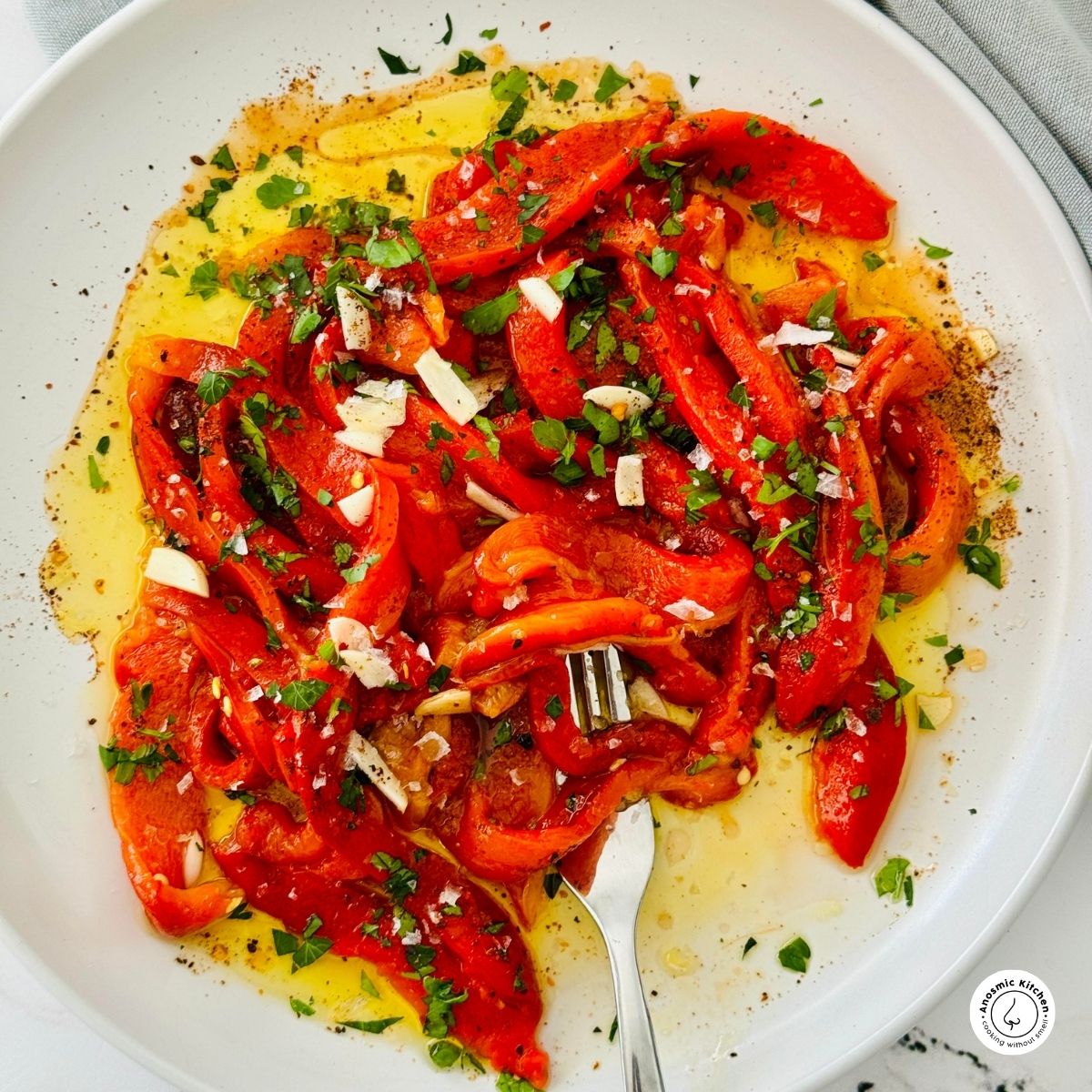 sliced roasted red peppers in oil on a white plate