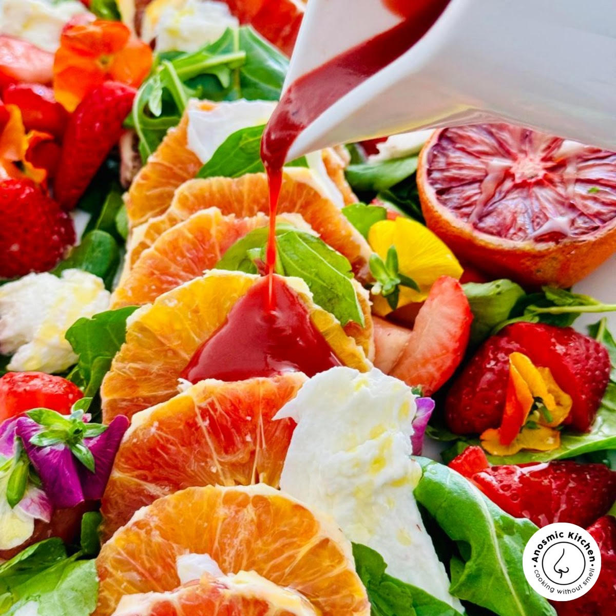 orange salad slices with a blood orange dressing pouring out the jug