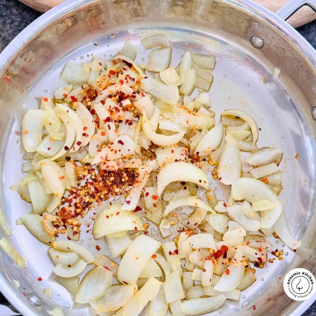 onion and dried pepper flakes in a pan relish