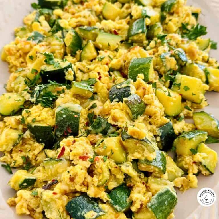 scrambled eggs and zucchini cooked on a serving platter