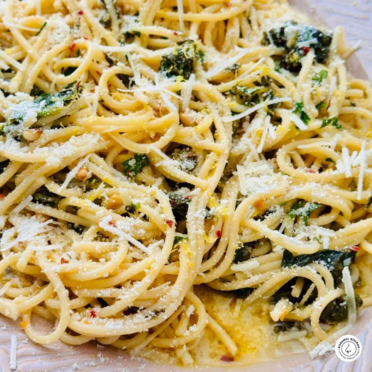 spaghetti lemon pasta with spinach and parmesan cheese on a platter.