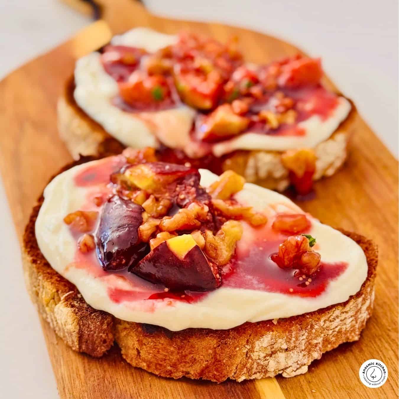 2 slices of toasted bread on a board with figs and mascarpone