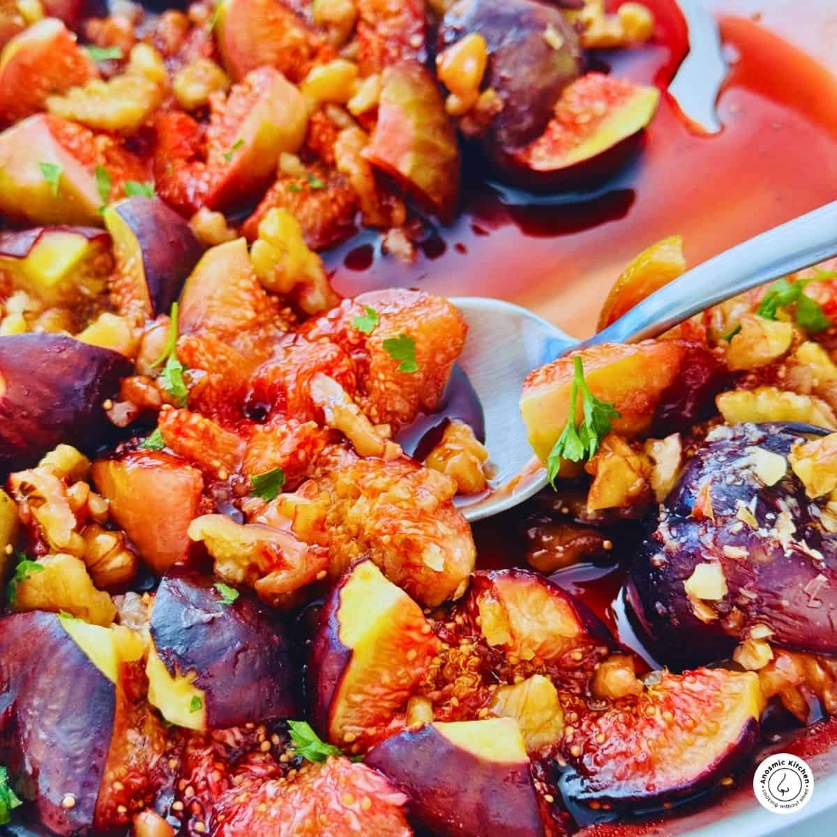 figs and nuts in a pan with a spoon.