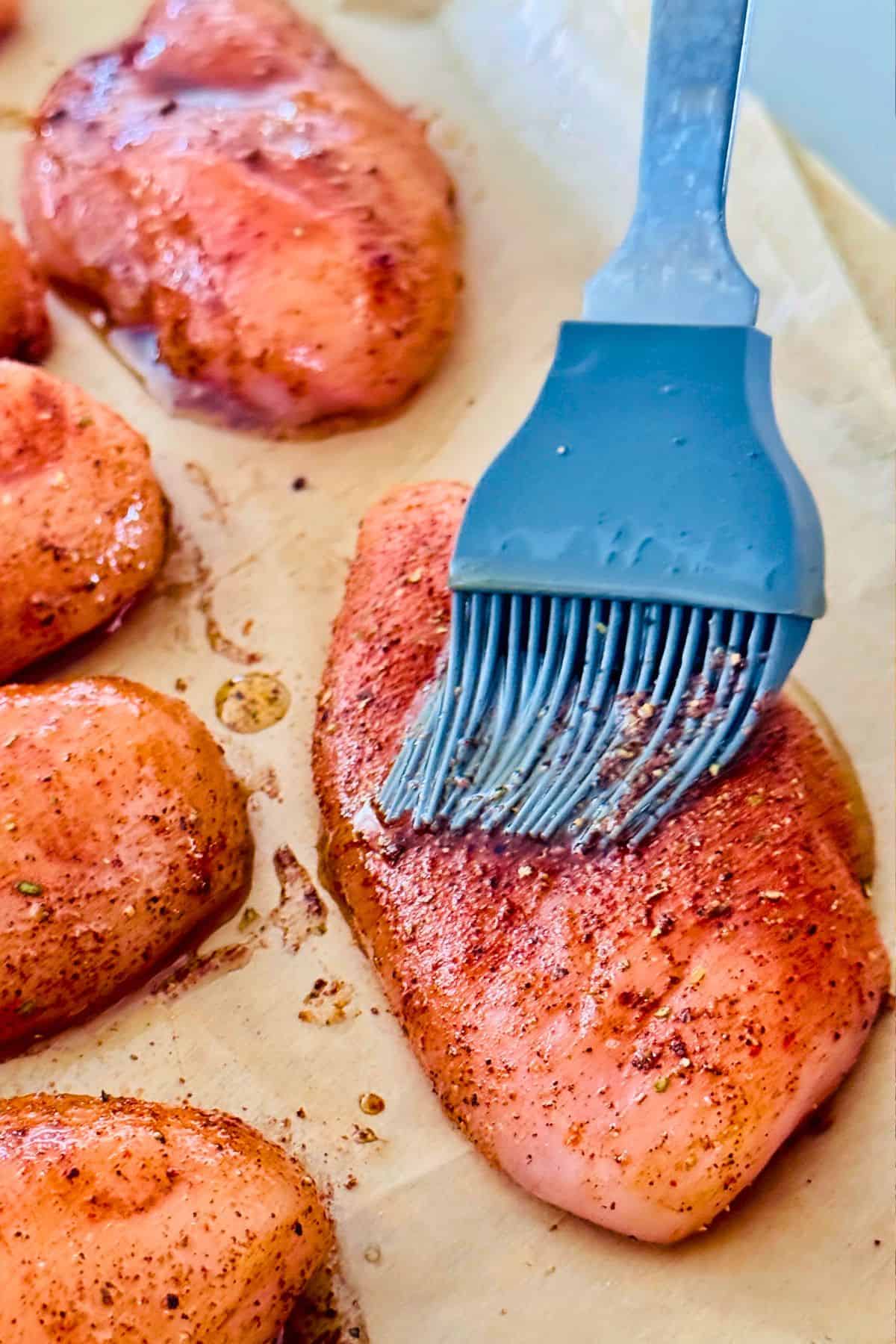 chicken breasts are being brushed with olive oil