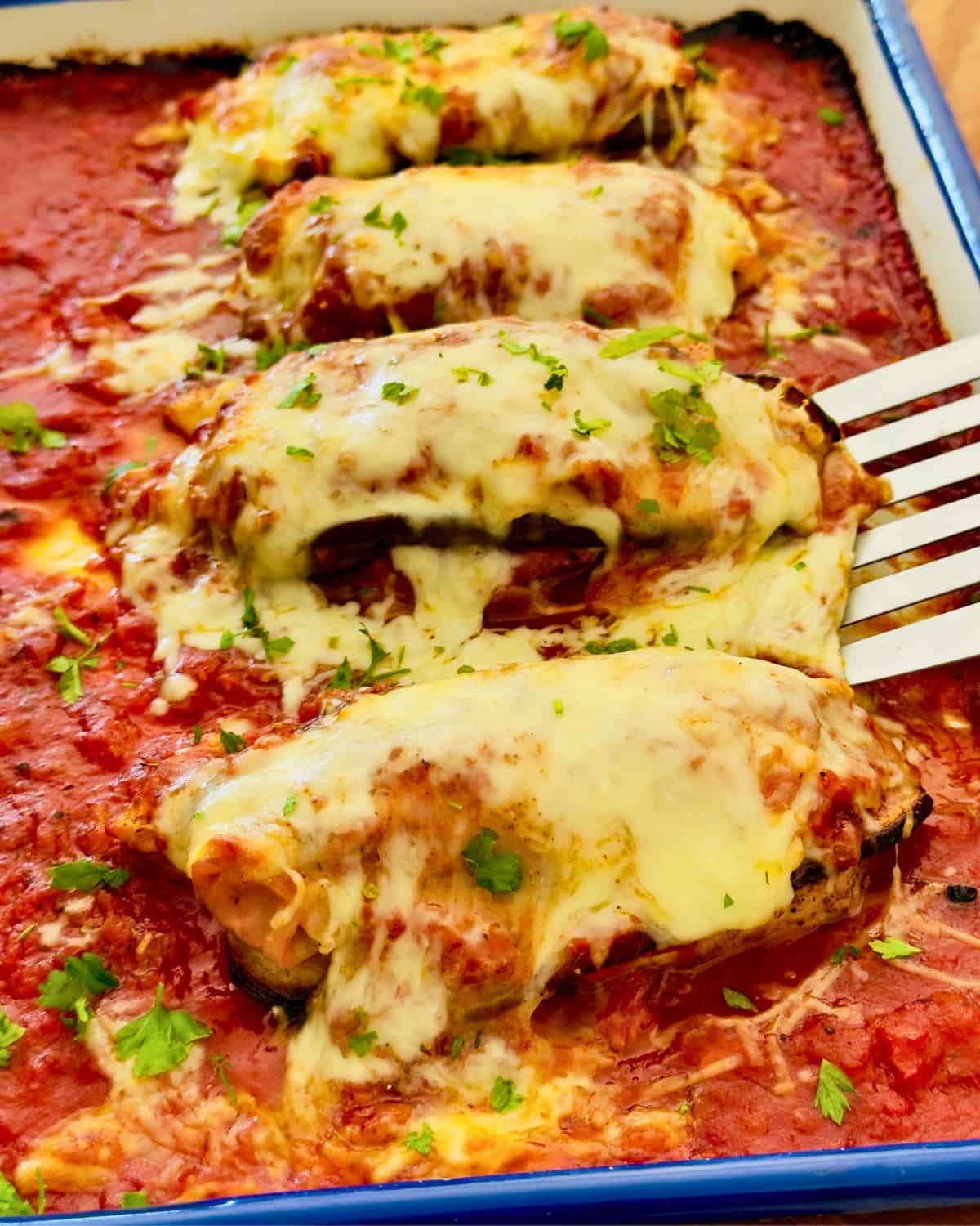 Baked chicken eggplant parmesan in tomato sauce with melted cheese in a casserole dish