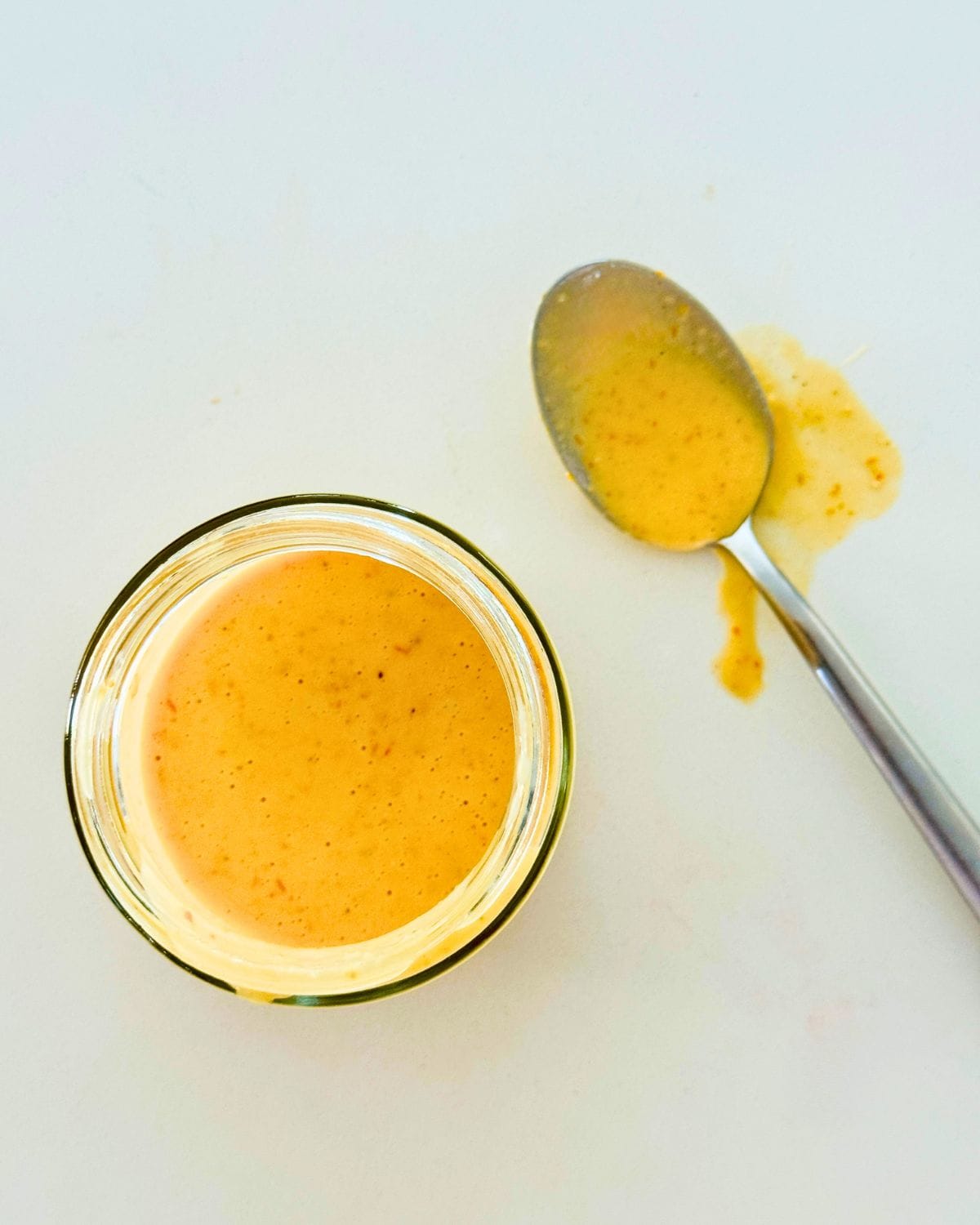 Creamy pink sauce in a jar with a spoon for serving
