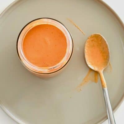 Creamy pink sauce in a jar with a spoon for serving