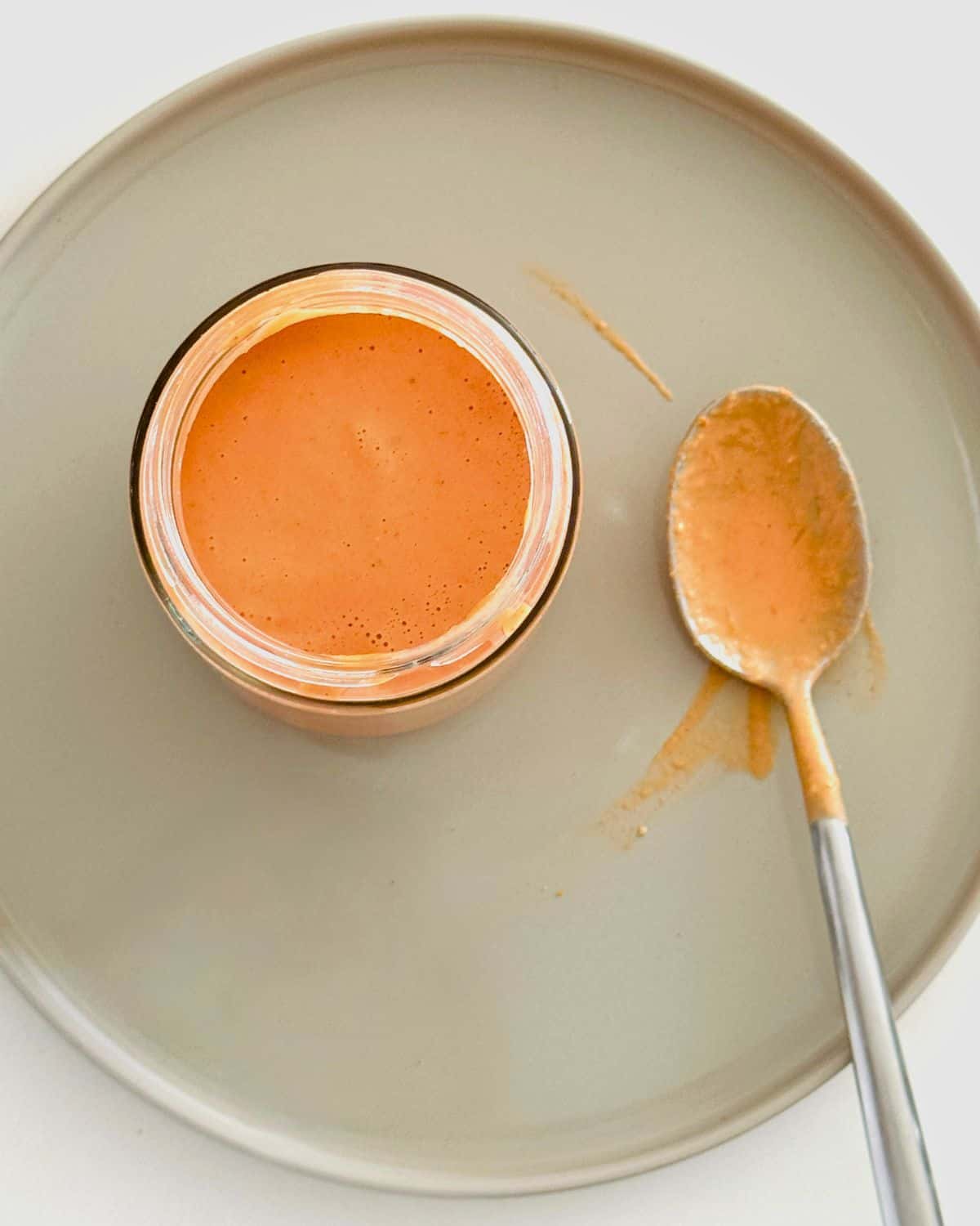 Creamy pink sauce in a jar with a spoon for serving