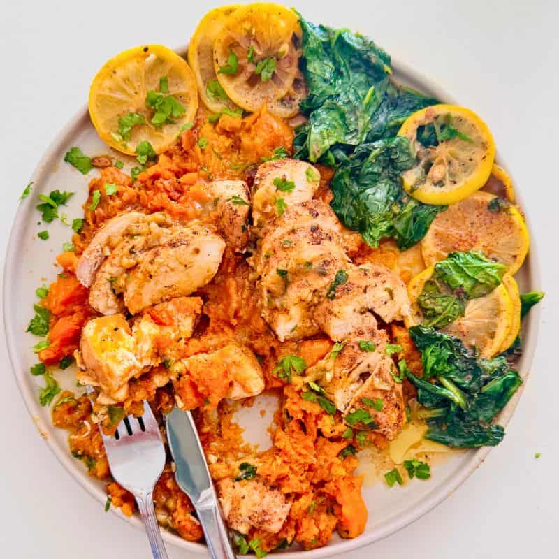 mashed sweet potato with sliced chicken breast, sauce and sauteed spinach.