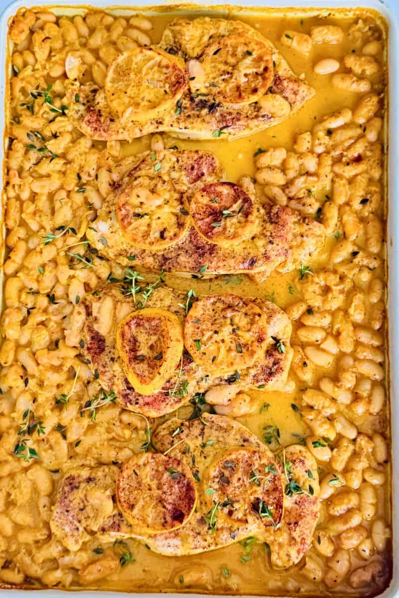 cooked chicken breast and beans in a spicy coconut sauce with lemon slices and thyme.