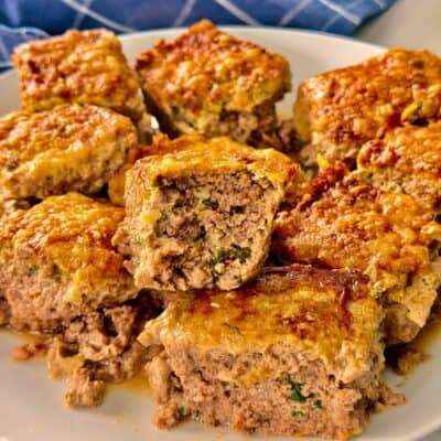 air fryer beef bites piled on a plate with one bitten into.
