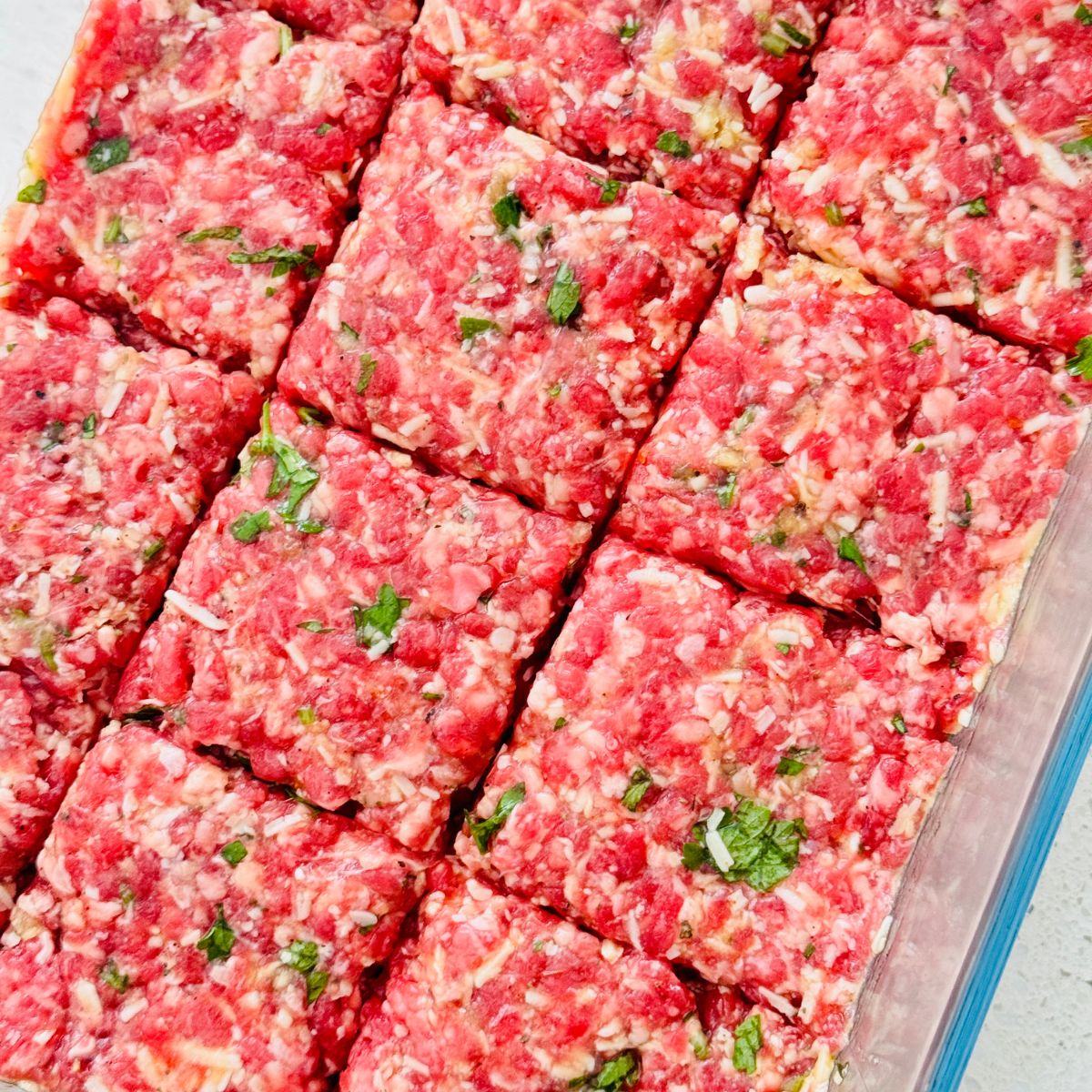 uncooked ground beef mince in a dish cut into squares
