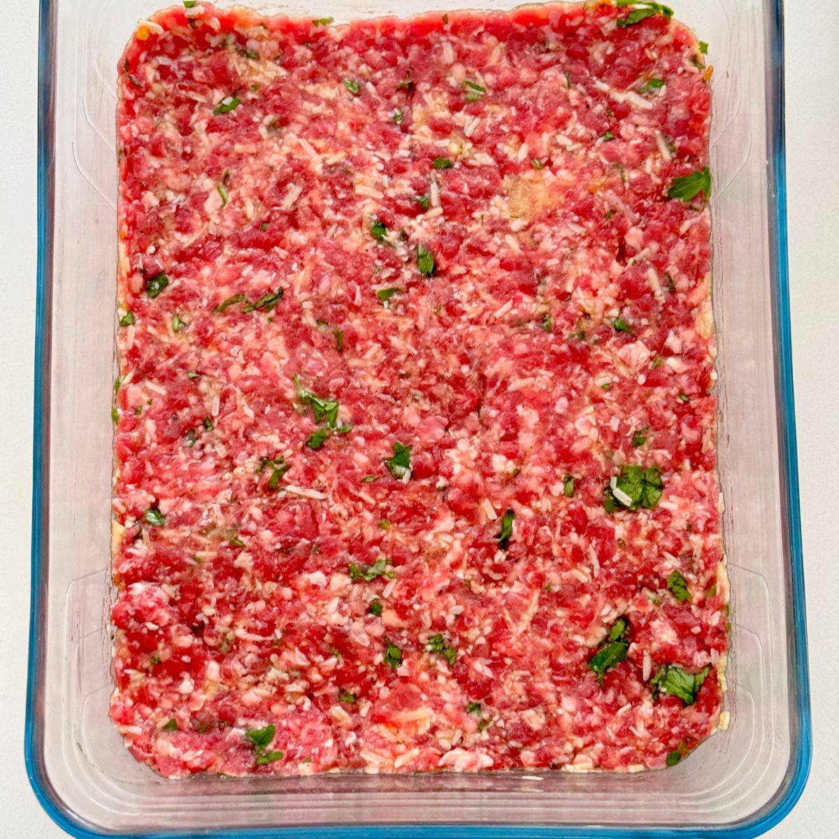 ground beef flattened into a pyrex dish