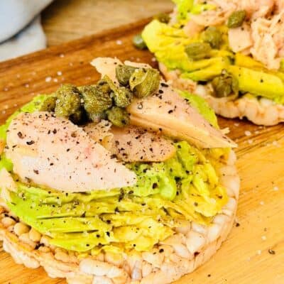 rice cake with smashed avocado, tuna chunks and capers