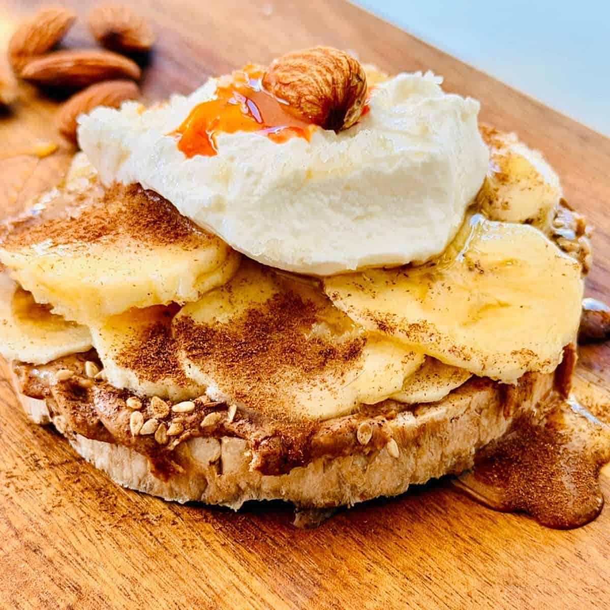 rice cake with nut butter, sliced banana, drizzled honey, cottage cheese with an almond for garnish and a drzzle of chili sauce.