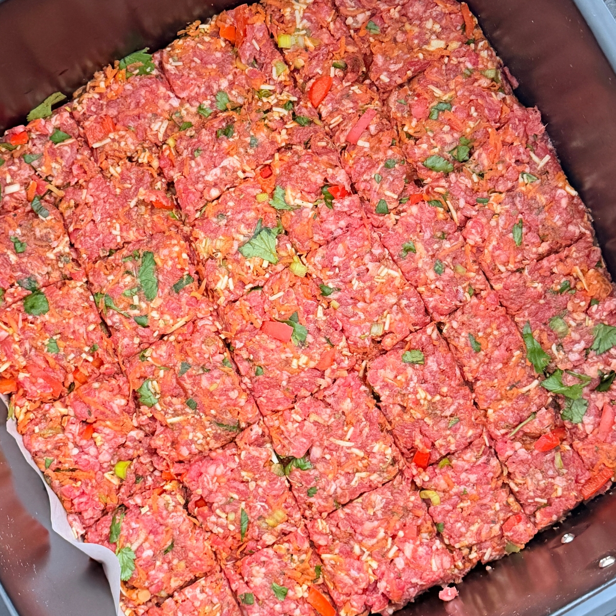 raw ground beef in an air fryer sliced into squares ready to be cooked