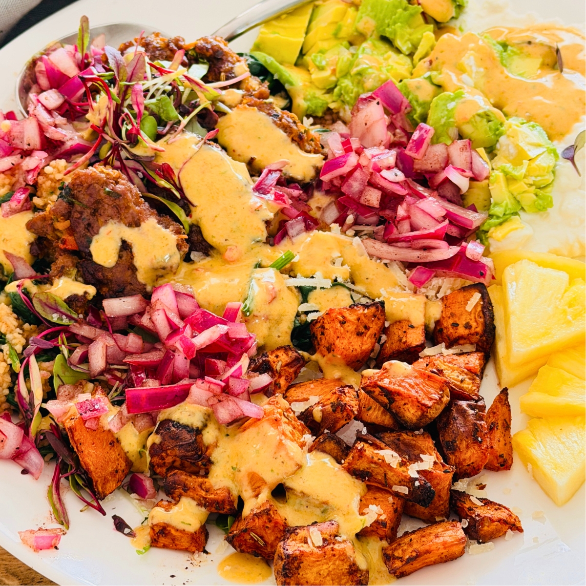 beef bites with avocado, sweet potato bowl served with avocado and a pink dressing.